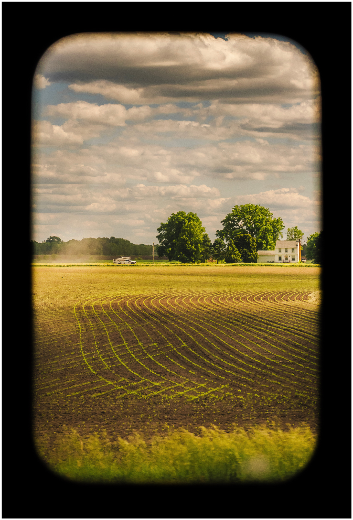 A printed photograph depicting a field under a cloudy sky, part of a series titled 'Portrait of America'.