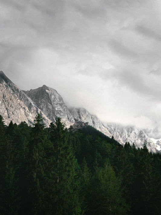 A landscape photo featuring mountains with clouds in the background, intended for mounting and framing.