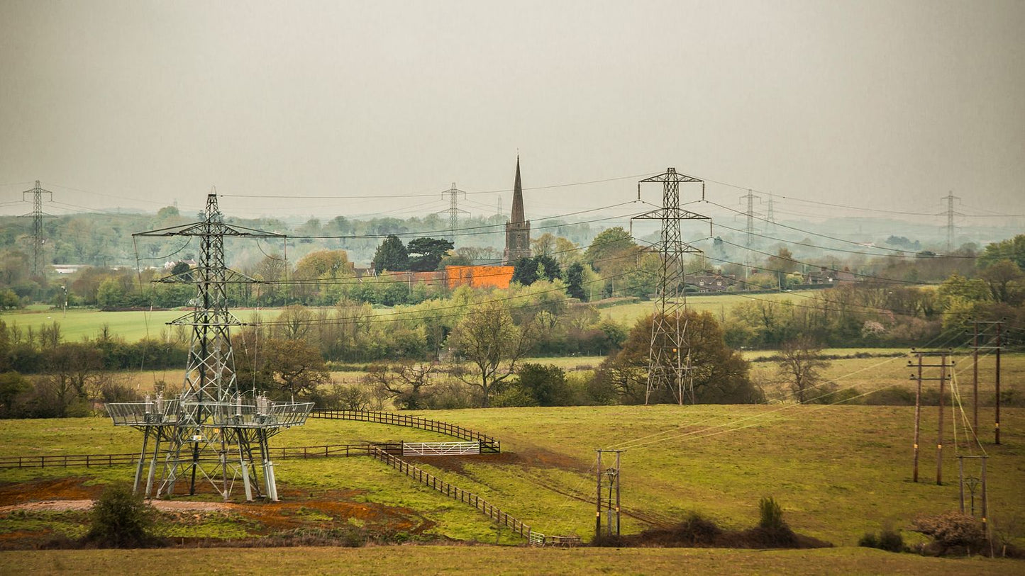 A fine art print featuring a rural landscape with power lines, a church, and a red-colored house.