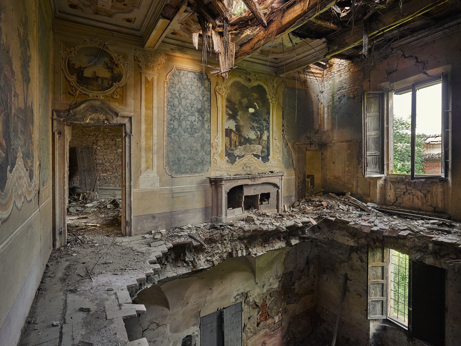 An image of a dilapidated room with a window, fireplace, and decorative wall patterns, indicating a historical or ruined building.