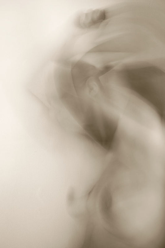 A blurred image of a person, possibly used as a creative art piece, with a brown tint 