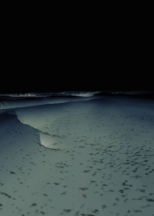 An image of a beach at night with visible waves and shadows.