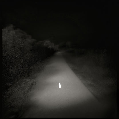 A black and white photo of a lonely road with a white line in the center, printed on a Giclée Hahnemühle photo rag.