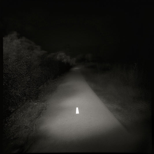 A black and white photo of a lonely road with a white line in the center, printed on a Giclée Hahnemühle photo rag.