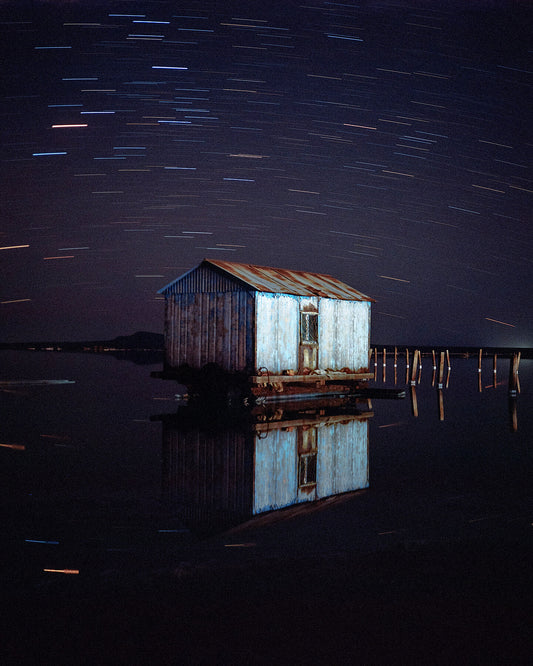 A photograph featuring a barn with a night sky background, displayed in a landscape orientation.