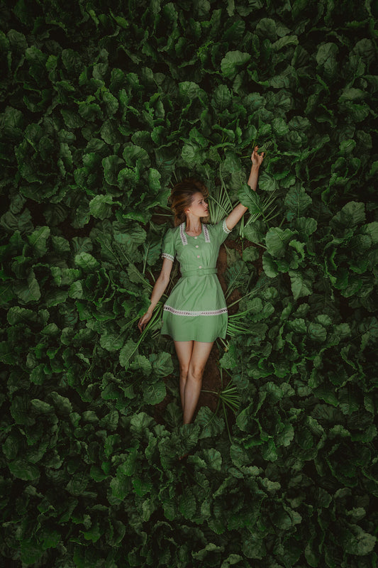 A photo print featuring a person in a green dress amidst green foliage.