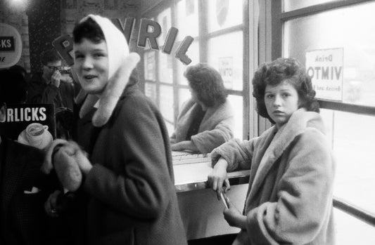Black and white photograph of two women from behind, having a conversation.