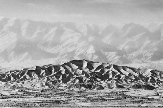 Black and white image of a mountainous landscape with a white border for mounting in a frame.
